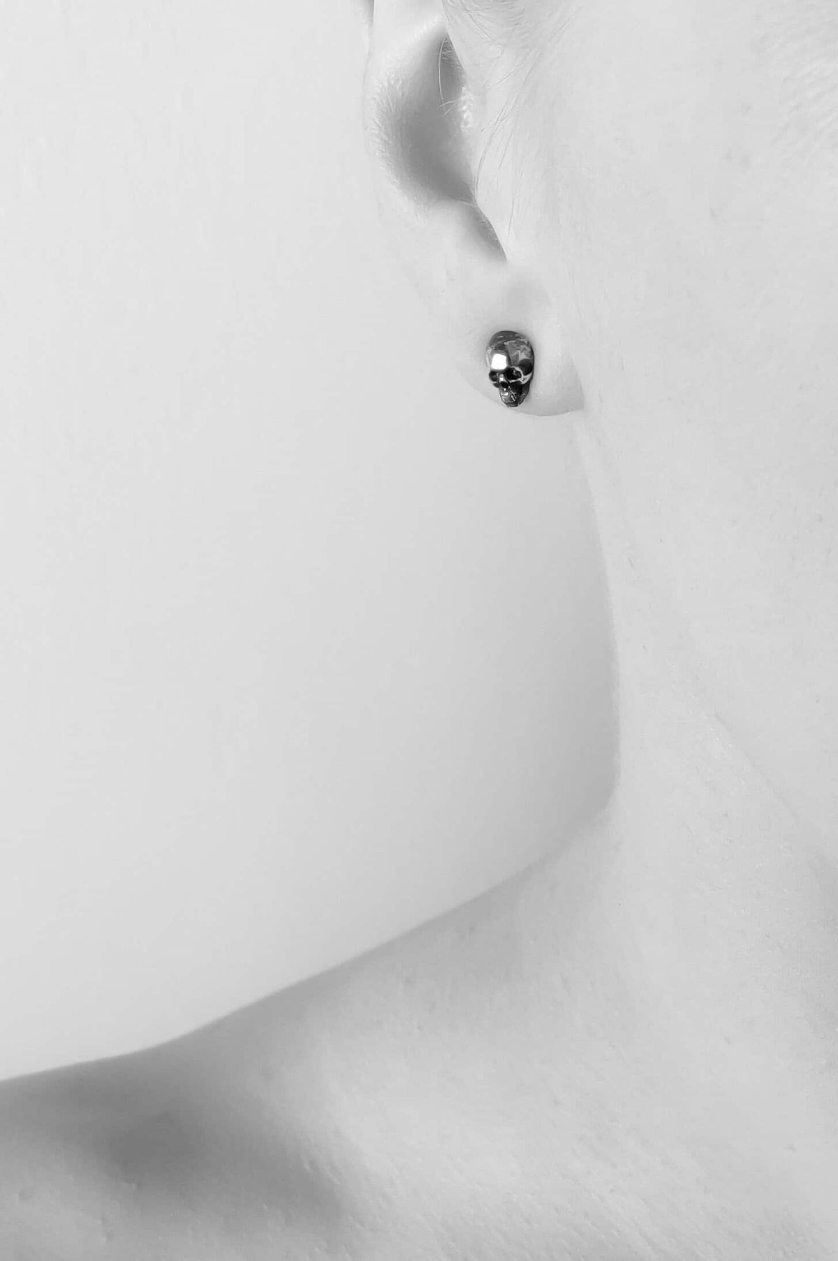 Skull studs in blackened sterling silver worn. Skull Collection by Heidi Vornan